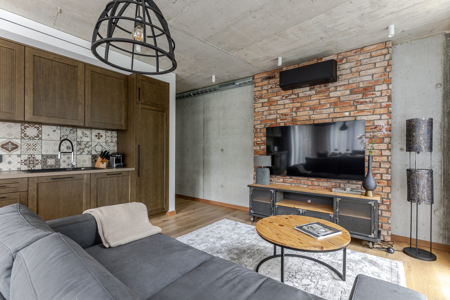 Moderni svetainė su dizaino baldais ir dideliais langais