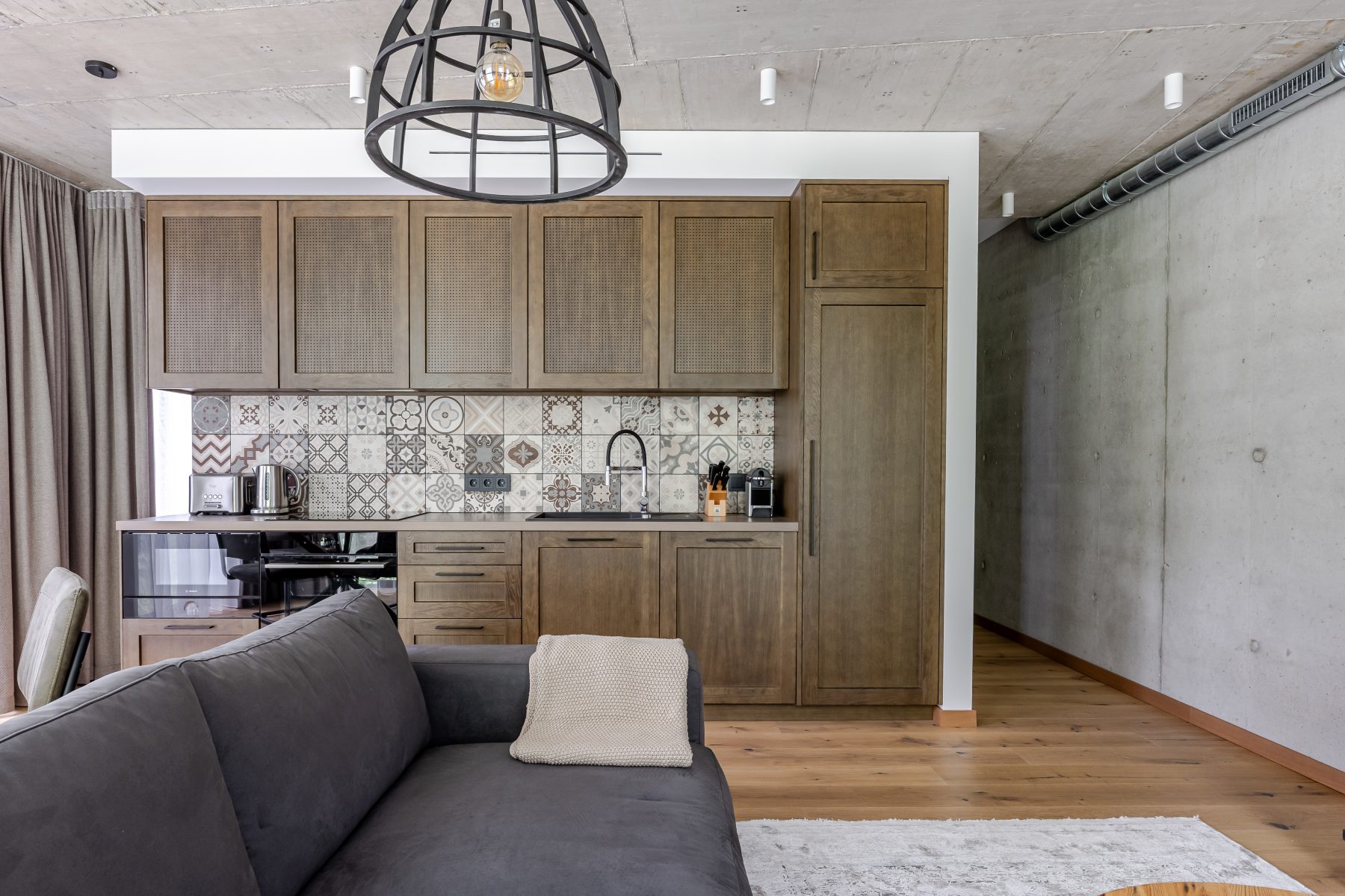 Moderni svetainė su dizaino baldais ir dideliais langais