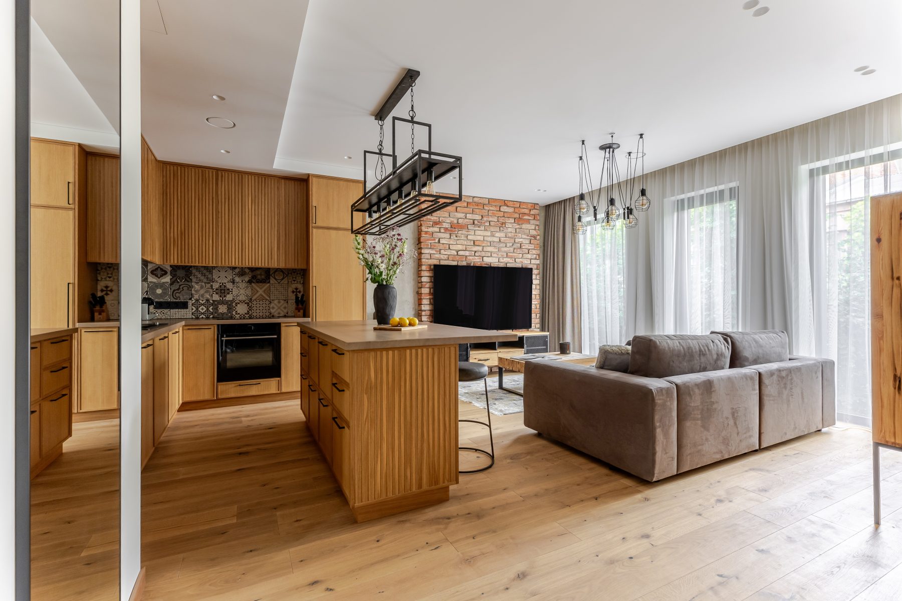 Šviesi svetainė su minkštais baldais ir medžio apdaila