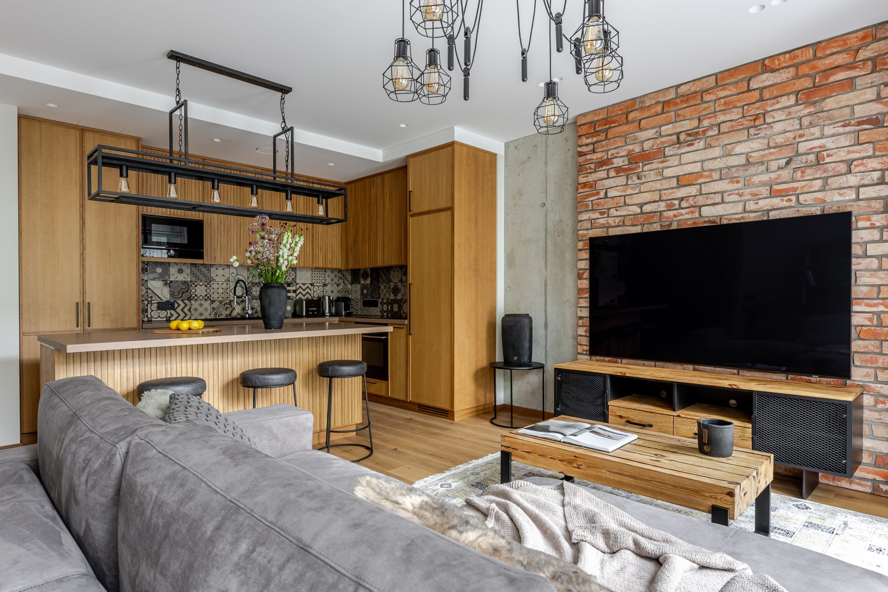 Šviesi svetainė su minkštais baldais ir medžio apdaila