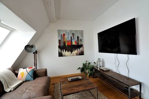 Poilsio zona su sofa ir televizoriumi antrame aukšte