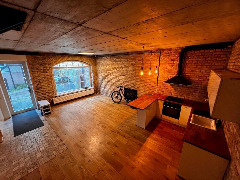 Modernus loft tipo buto interjeras su antru aukštu ir plytų sienomis