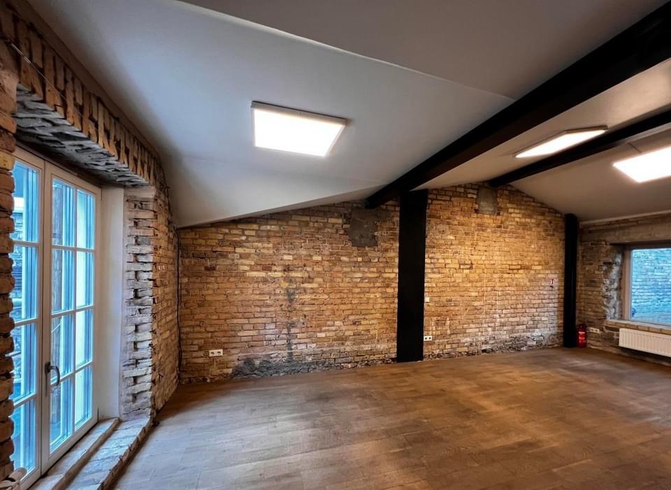 Modernus loft tipo buto interjeras su antru aukštu ir plytų sienomis