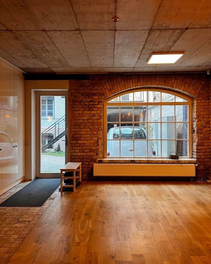Modernus loft tipo buto interjeras su atvira virtuve ir plytų sienomis