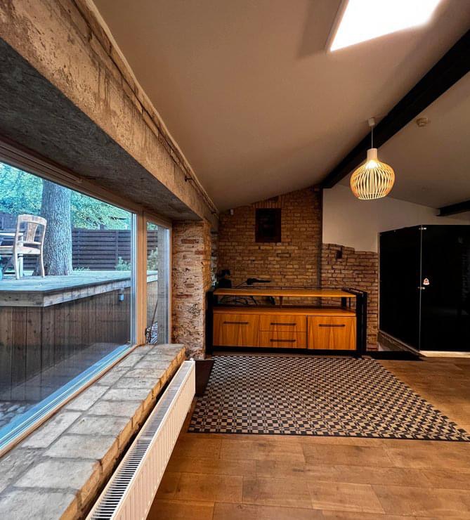 Modernus loft tipo buto interjeras su atvira virtuve ir plytų sienomis